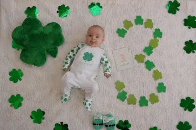 Newborn photography in Dublin, baby sleeping peacefully in parents' arms at home