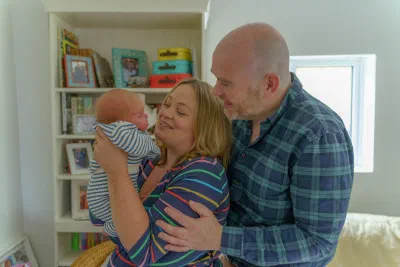 Parents with their newborn in the nursery during an at-home session in Dublin