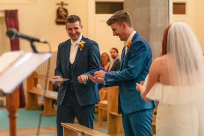 Close photograph of the ring exchange during the ceremony, the couple’s hands and the priest’s book