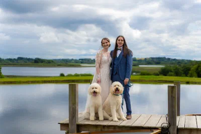 Couple with golden retrievers on a lakeside dock, Glasson Lakehouse
