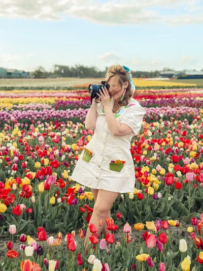 Gabriela Duffy, Dublin wedding photographer, shooting with her camera in a field of tulips
