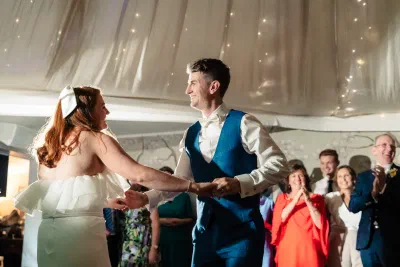 Bride and groom during their first dance beneath the draped ceiling and fairy lights