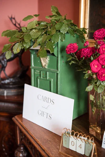 Cards and gifts sign beside a vintage green postbox and pink roses at an Orlagh House wedding