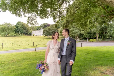 Bride and groom laughing together in the grounds at Orlagh House, the Georgian house behind them