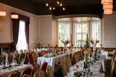 Long banquet tables set for a wedding dinner in the dining room at Orlagh House
